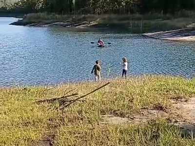 Crianças brincando na orla da represa